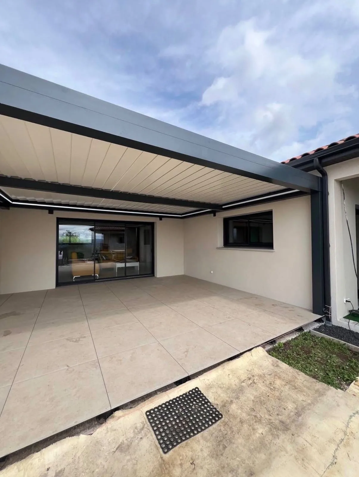 Pergola adossée HCR sur terrasse carrelée, configuration idéale pour une fermeture vitrée verticale
