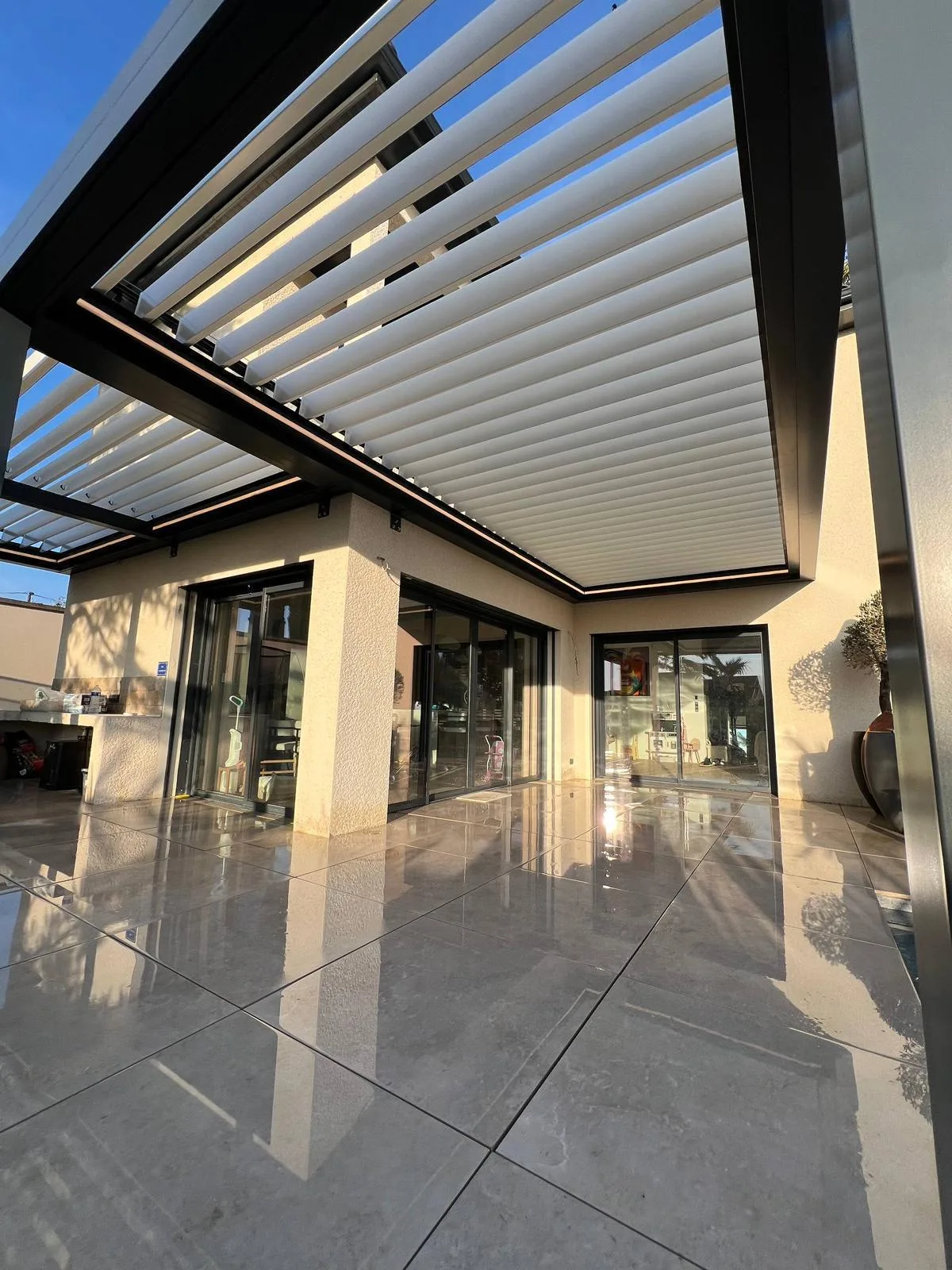 Pergola bioclimatique à lames orientables à l’heure dorée, réalisation HCR