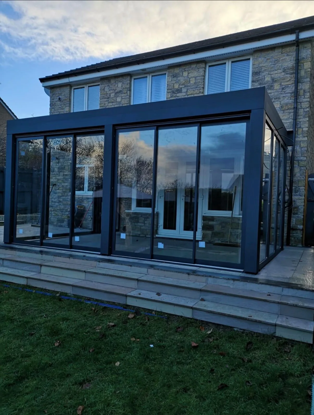 Véranda aluminium anthracite à toit isolé, réalisation HCR